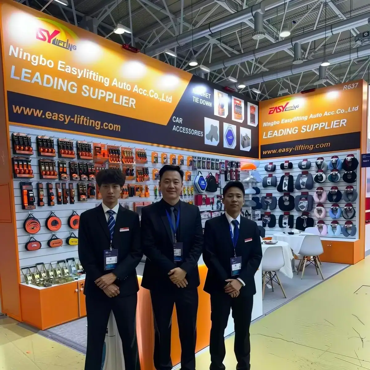 Three representatives standing in front of Ningbo Easylifting auto accessories booth at trade show, showcasing car parts and accessories for automotive professionals.